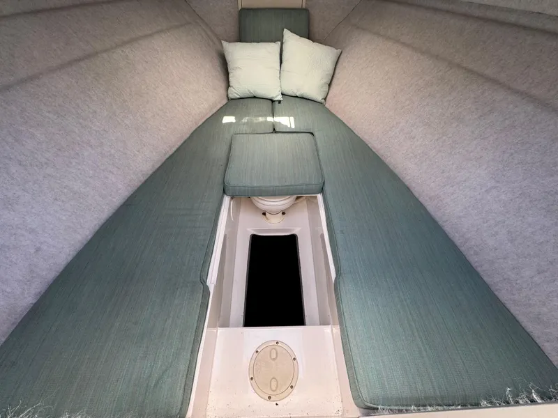 Slide: The Image of Interior cabin of 1999 Marlin 350 SF boat with teal cushions and pillows. - 7