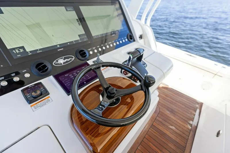 Slide: The Image of 2024 Valhalla V55 boat helm with advanced navigation screens and wooden steering wheel. - 17
