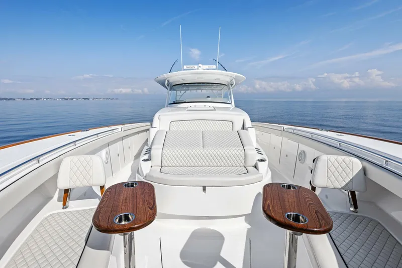 Slide: The Image of 2024 Valhalla V55 boat with luxurious seating and wooden tables on calm water. - 23
