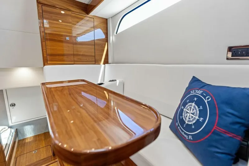 Slide: The Image of Luxurious interior of 2024 Valhalla V55 boat with wooden table and nautical-themed pillow. - 30