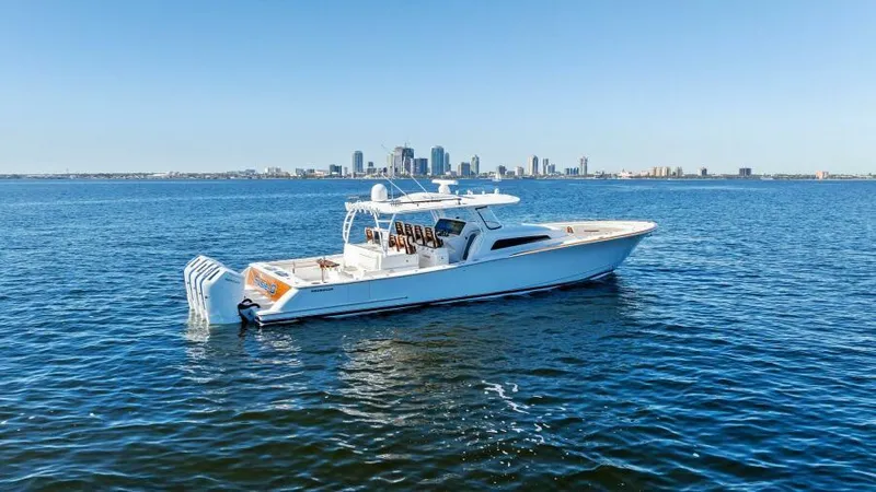 Slide: The Image of 2024 Valhalla Boatworks V55 cruising on open water with city skyline backdrop. - 43