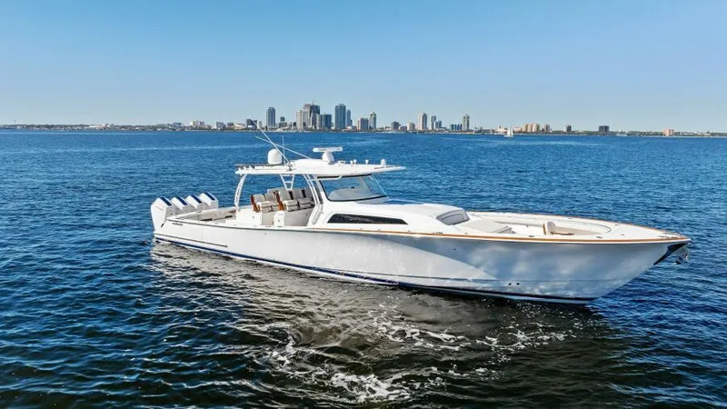 Slide: The Image of 2024 Valhalla Boatworks V55 cruising on open water with city skyline backdrop. - 44