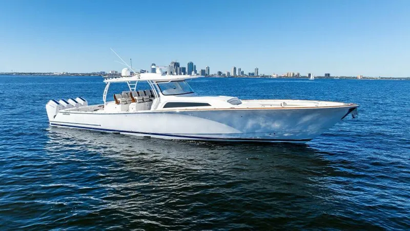 Slide: The Image of 2024 Valhalla Boatworks V55 cruising on open water with city skyline in background. - 46
