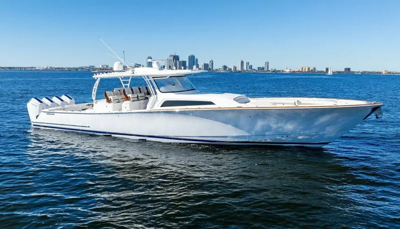 Slide: The Image of 2024 Valhalla Boatworks V55 cruising on open water with city skyline backdrop. - 47