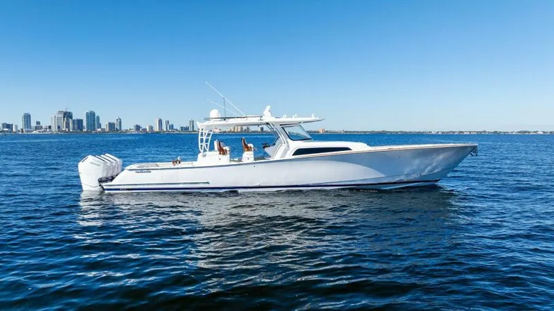 Slide: The Image of 2024 Valhalla Boatworks V55 cruising on open water with city skyline in background. - 48