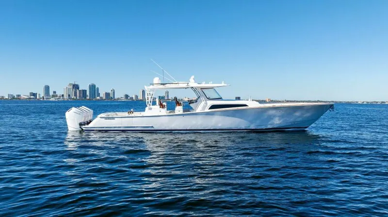 Slide: The Image of 2024 Valhalla Boatworks V55 cruising on open water with city skyline backdrop. - 49