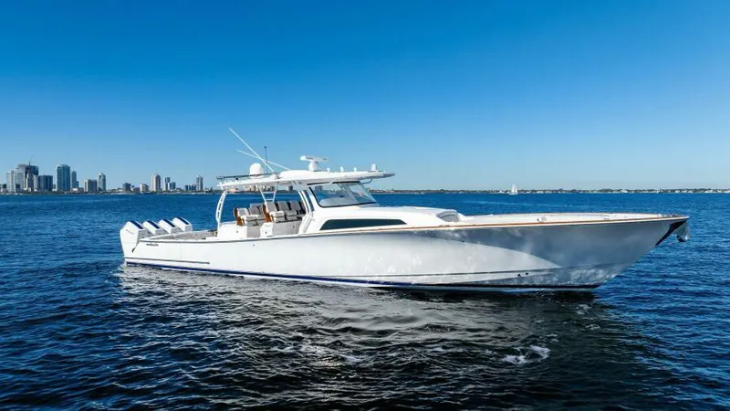 Slide: The Image of 2024 Valhalla Boatworks V55 cruising on open water with city skyline in background. - 52