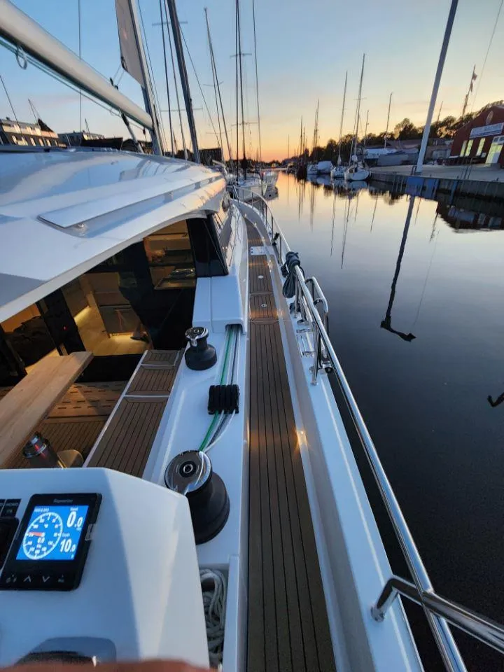 Slide: The Image of 2025 Moody 48 DS yacht docked at sunset, featuring sleek design and modern navigation instruments. - 21