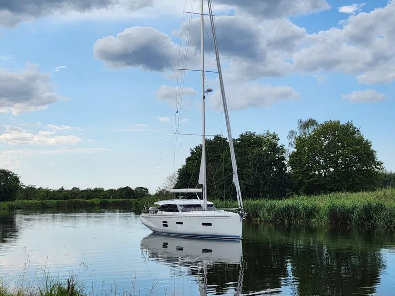 Slide: The Image of Sailing yacht Moody 48 DS 2025 on a tranquil river under a partly cloudy sky. - 3