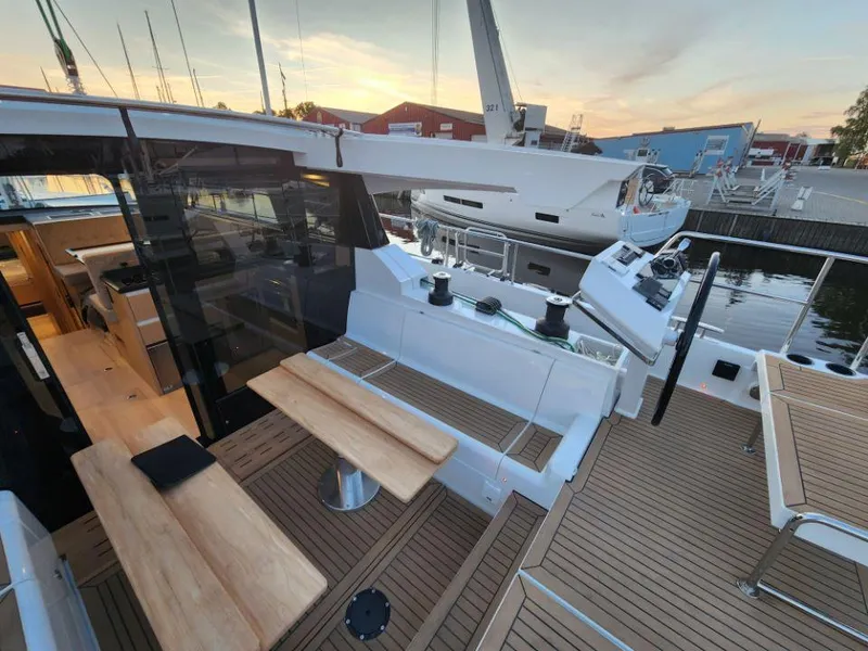 Slide: The Image of Modern 2025 Moody 48 DS yacht with sleek deck and elegant seating area at sunset. - 32