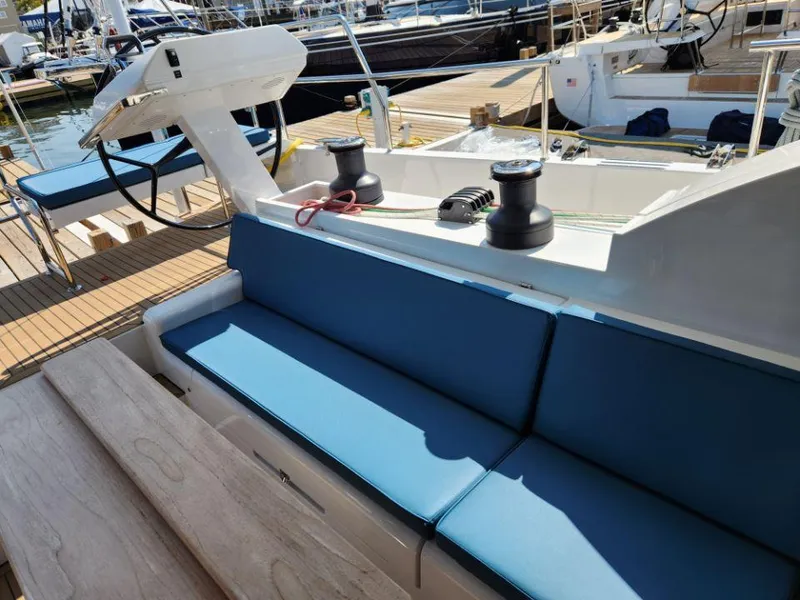 Slide: The Image of Luxurious Moody 48 DS yacht deck with blue seating, winches, and steering wheel, 2025 model. - 34