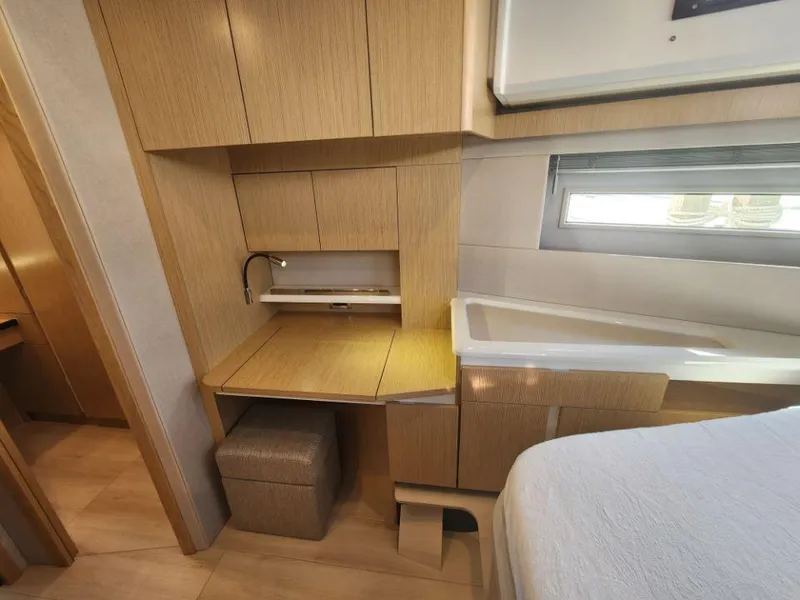 Slide: The Image of Modern interior of 2025 Moody 48 DS yacht with wooden cabinetry and compact workspace. - 45