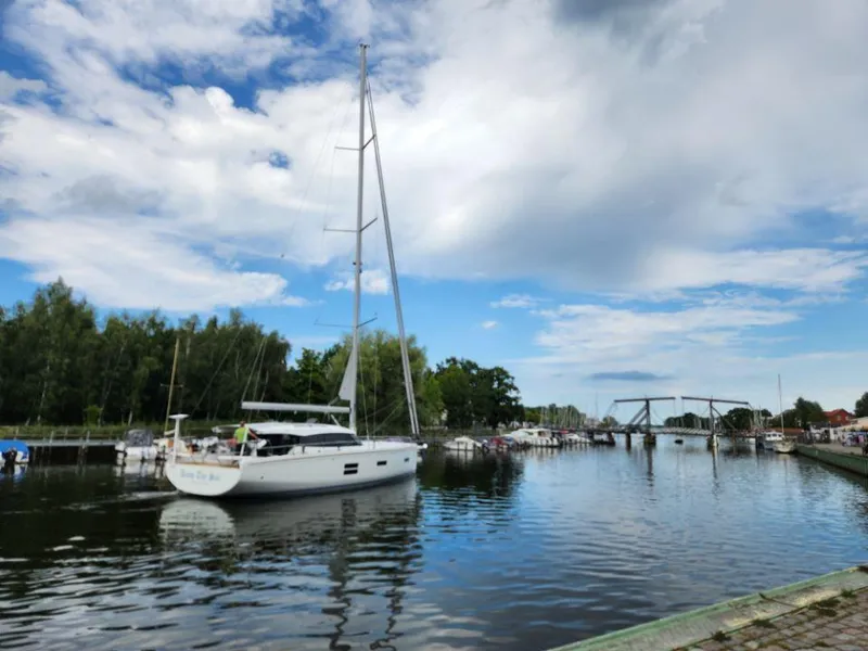 Slide: The Image of Sailing yacht Moody 48 DS, 2025 model, cruising on a serene river under a partly cloudy sky. - 5