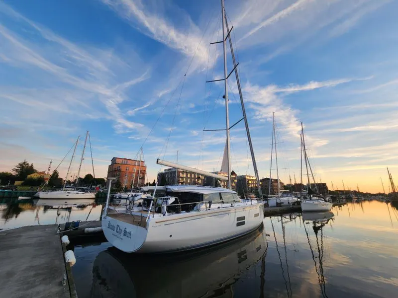 Slide: The Image of Sailboats docked at sunset, featuring a 2025 Moody 48 DS yacht. - 7