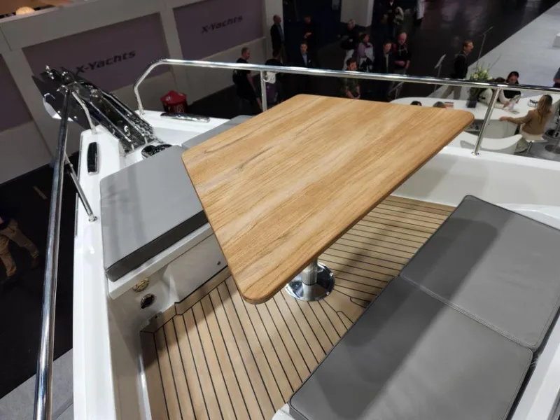 Slide: The Image of Deck seating area on 2025 Moody 48 DS yacht with wooden table and cushions. - 9