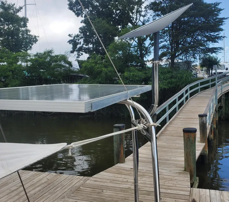 Slide: The Image of Beneteau First 42 sailboat docked, featuring solar panels, 1984 model. - 13