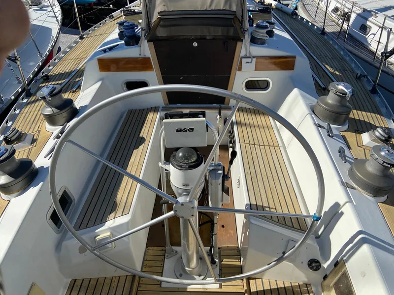 Slide: The Image of Cockpit of 1984 Beneteau First 42 sailboat with large steering wheel and wooden deck. - 16