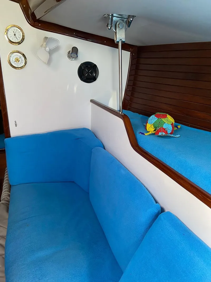Slide: The Image of Interior of 1984 Beneteau First 42 sailboat with blue seating and wooden accents. - 21