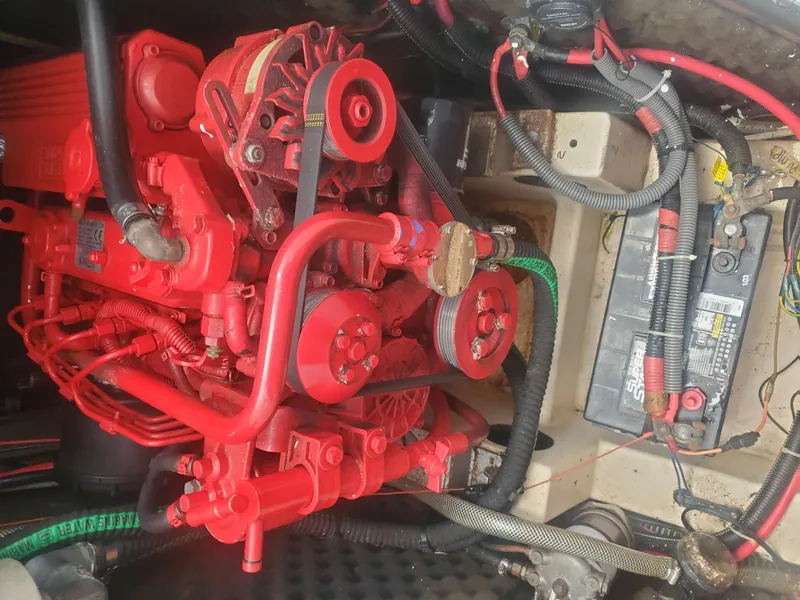 Slide: The Image of Red engine of a 1984 Beneteau First 42 sailboat, with visible wiring and battery. - 24