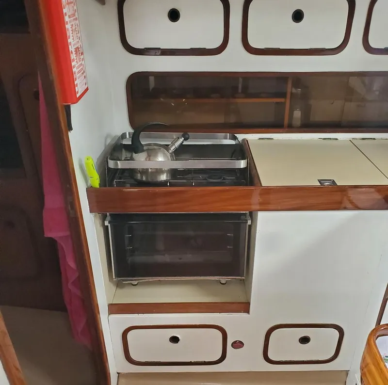 Slide: The Image of 1984 Beneteau First 42 yacht kitchen with stove and storage cabinets. - 31