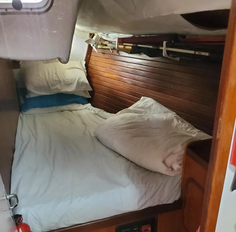 Slide: The Image of Cozy cabin interior of 1984 Beneteau First 42 sailboat with wooden paneling and bedding. - 34