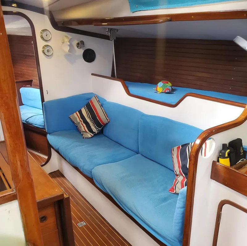 Slide: The Image of Interior of 1984 Beneteau First 42 sailboat with blue seating and striped pillows. - 35