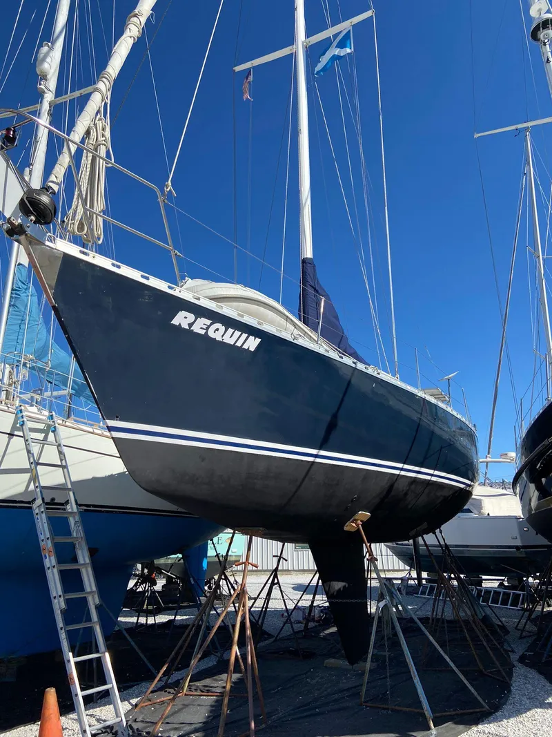Slide: The Image of 1984 Beneteau First 42 sailboat on dry dock, blue hull, clear sky background. - 4