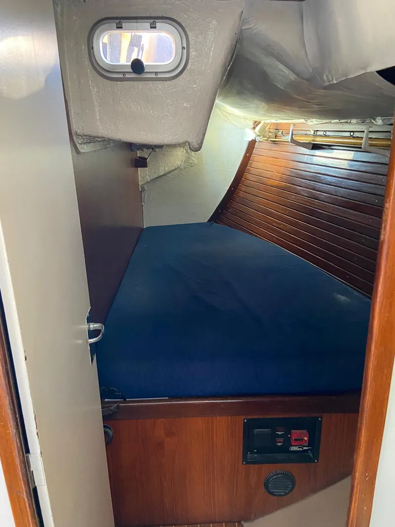 Slide: The Image of 1984 Beneteau First 42 sailboat cabin with blue bedding and wooden interior. - 46