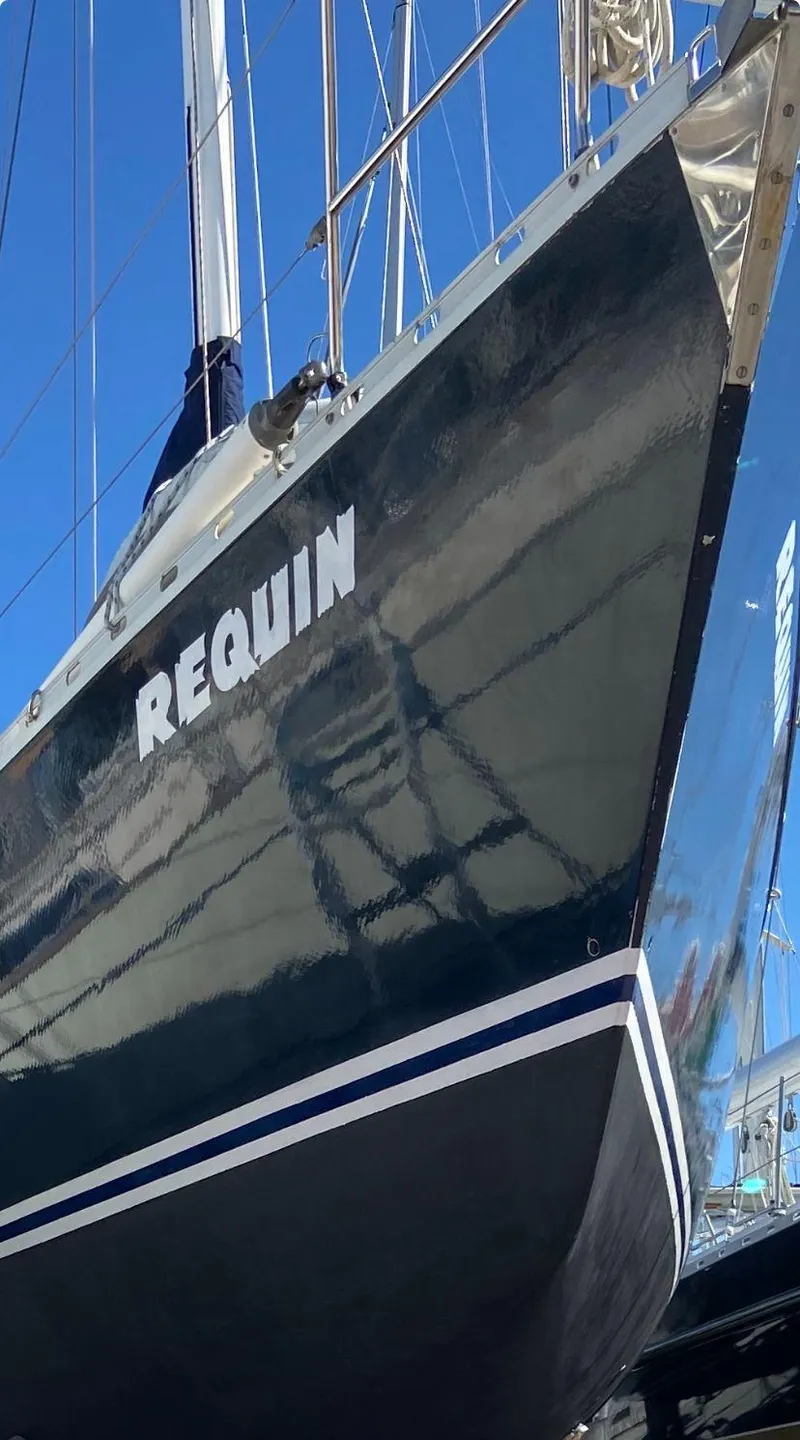 Slide: The Image of 1984 Beneteau First 42 sailboat named "Requin" with sleek black hull. - 5
