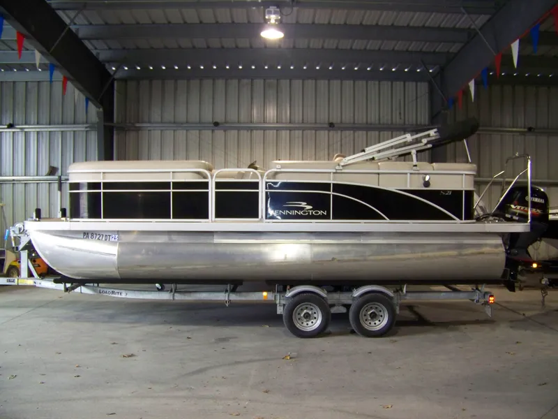 Slide: The Image of 2018 Bennington 21SL pontoon boat on trailer in a metal storage facility. - 1