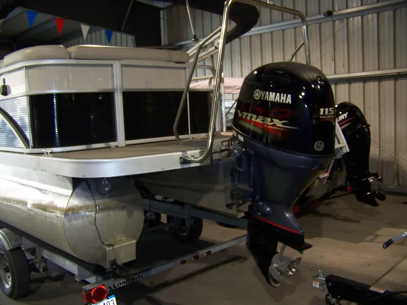 Slide: The Image of 2018 Bennington 21SL pontoon boat with Yamaha outboard motor in a garage. - 2