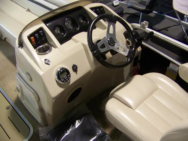 Slide: The Image of 2018 Bennington 21SL boat dashboard with steering wheel and beige captain's chair. - 4
