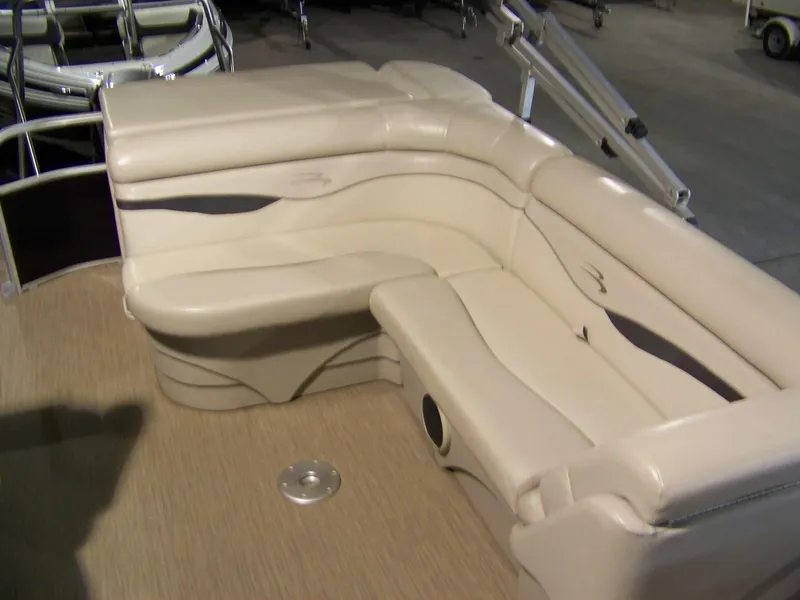 Slide: The Image of 2018 Bennington 21SL boat interior with beige seating and carpeted floor. - 7