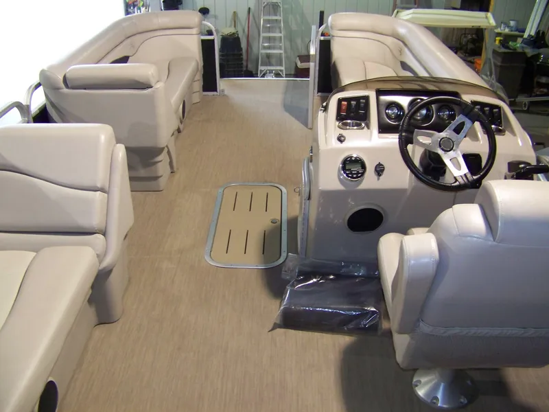 Slide: The Image of Interior of 2018 Bennington 21SL pontoon boat with beige seating and steering console. - 9
