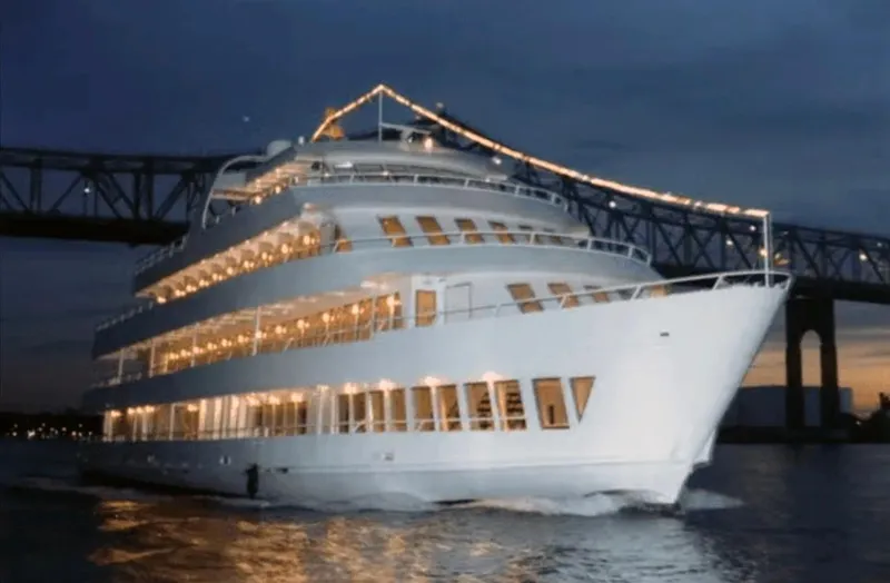 Slide: The Image of Elegant Blount 130 Dinner Cruise yacht illuminated at night, 1979 model, under a bridge. - 2