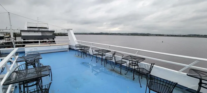 Slide: The Image of Upper deck of 1979 Blount 130 Dinner Cruise with empty tables and chairs, overlooking water. - 5