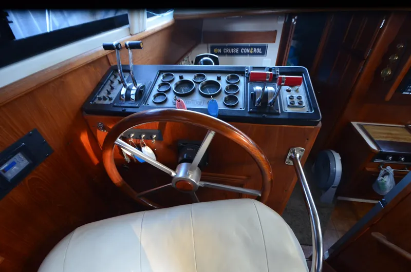 Slide: The Image of 1988 Carver 4207 Aft Cabin MY helm with wooden steering wheel and control panel. - 16