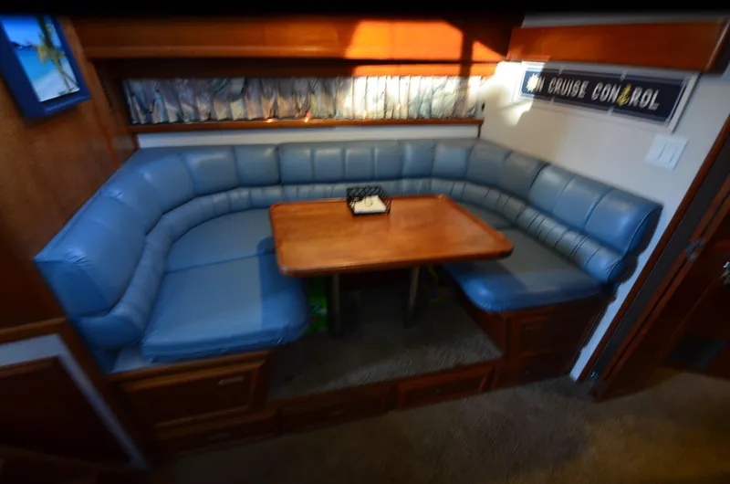 Slide: The Image of 1988 Carver 4207 Aft Cabin MY interior with blue cushioned seating and wooden table. - 17