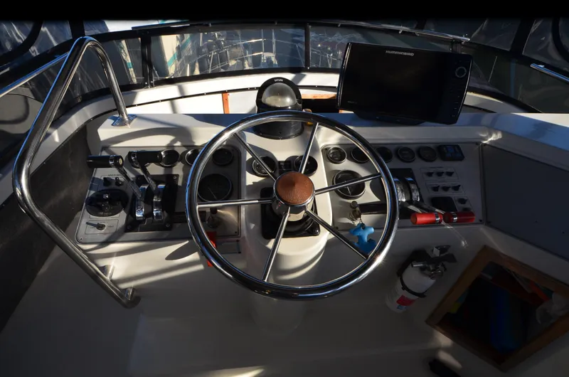 Slide: The Image of 1988 Carver 4207 Aft Cabin MY helm with steering wheel and navigation controls. - 20