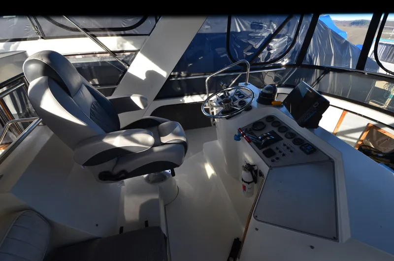Slide: The Image of 1988 Carver 4207 Aft Cabin MY helm with captain's chair and control panel. - 23