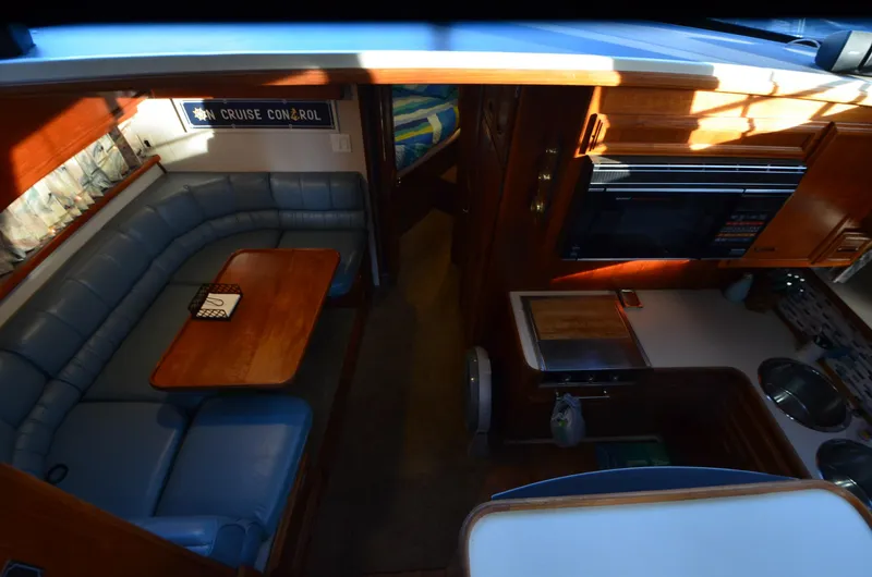 Slide: The Image of 1988 Carver 4207 Aft Cabin MY interior with seating, table, and kitchenette. - 26