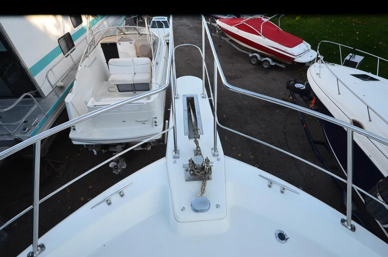 Slide: The Image of 1988 Carver 4207 Aft Cabin MY bow view with surrounding boats in storage. - 34