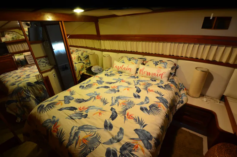 Slide: The Image of 1988 Carver 4207 Aft Cabin MY bedroom with tropical bedding and decorative pillows. - 8