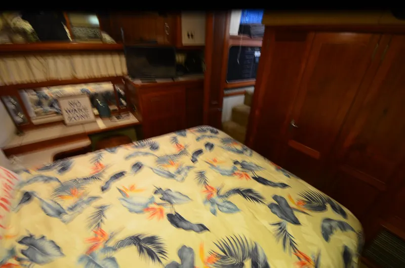 Slide: The Image of 1988 Carver 4207 Aft Cabin MY interior with floral bedspread and wooden cabinetry. - 9