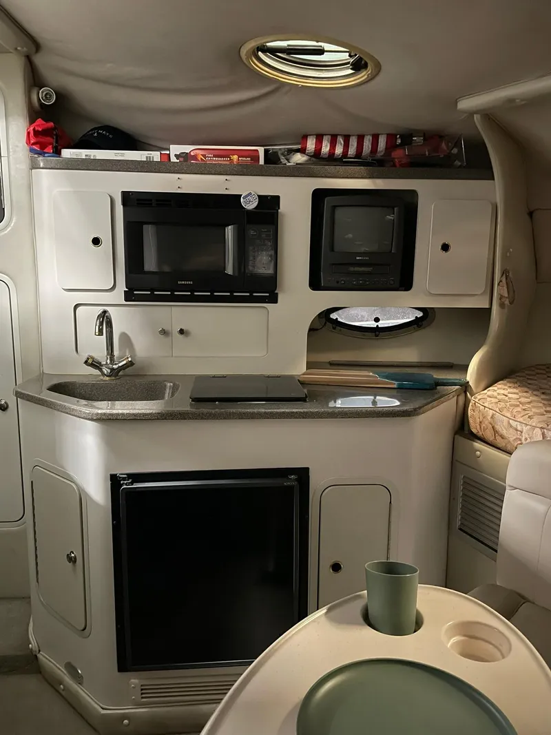 Slide: The Image of Interior of 2000 Crownline 290 CR boat with kitchenette and seating area. - 19