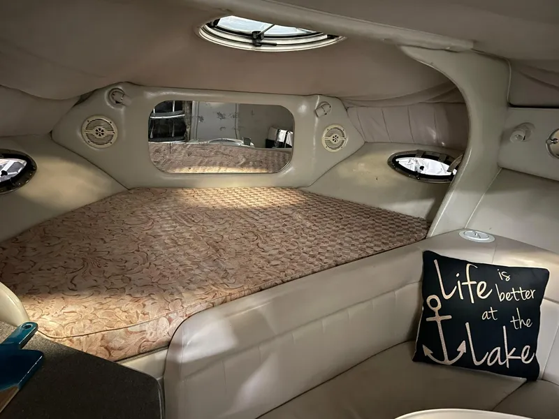 Slide: The Image of Interior of 2000 Crownline 290 CR boat with cozy bed and decorative pillow. - 21