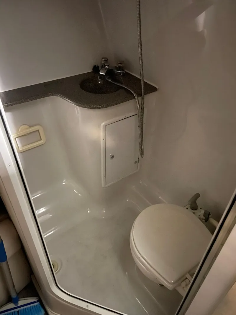 Slide: The Image of Compact bathroom in 2000 Crownline 290 CR boat with sink and toilet. - 24