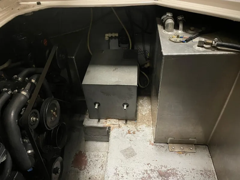 Slide: The Image of Engine compartment of 2000 Crownline 290 CR boat, showing mechanical components and storage area. - 29