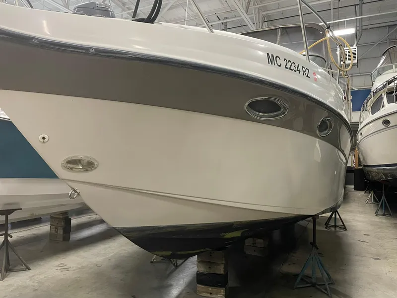 Slide: The Image of 2000 Crownline 290 CR boat in storage, elevated on stands indoors. - 5