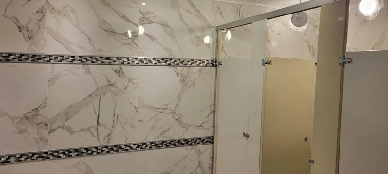 Slide: The Image of Marble-tiled bathroom with modern lighting and partitioned stalls, Custom Victory 11, 1981. - 15